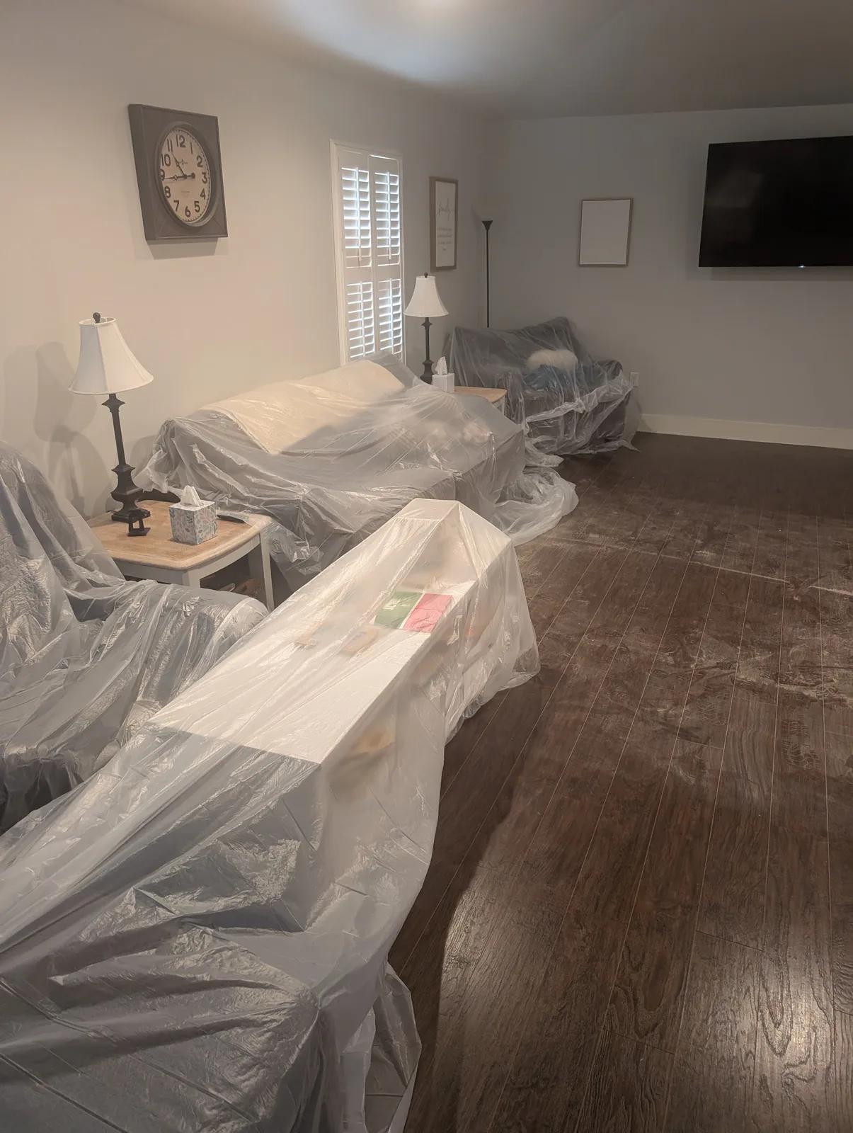Furniture and belongings protected under plastic sheeting during fire restoration work