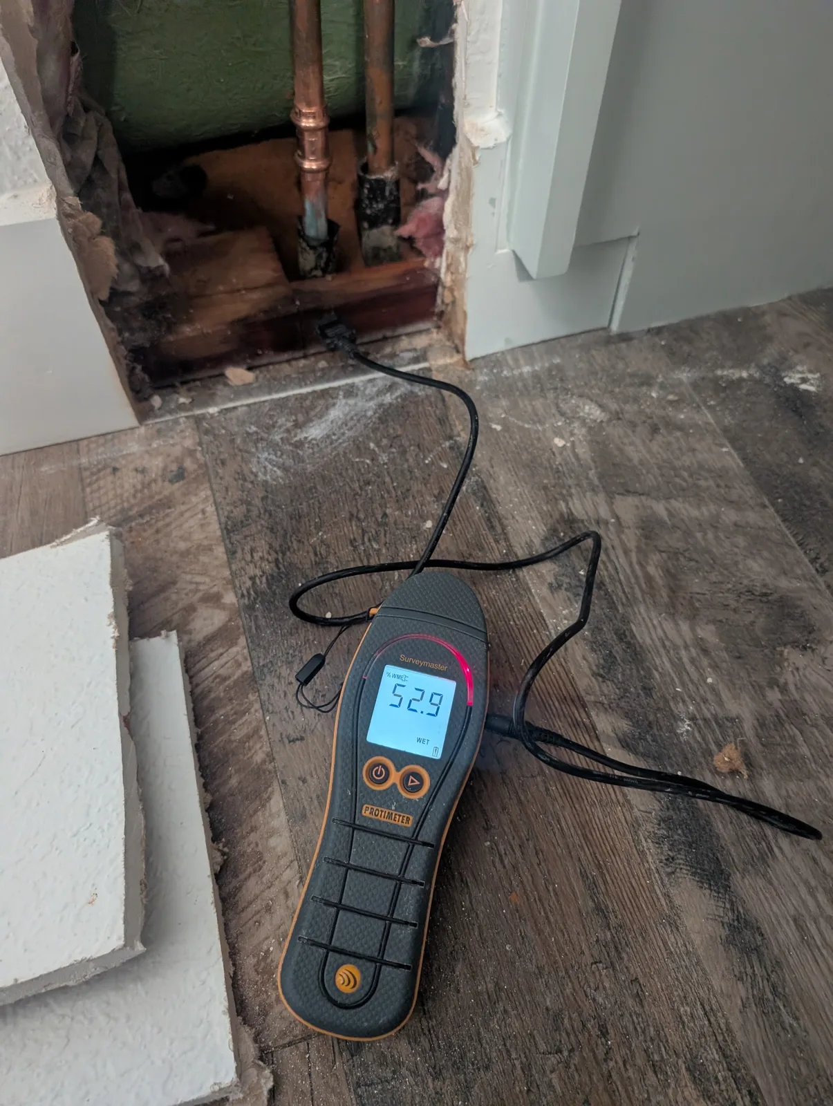 Moisture meter reading WET on storm-damaged wall framing during dry-out in Prosper, TX